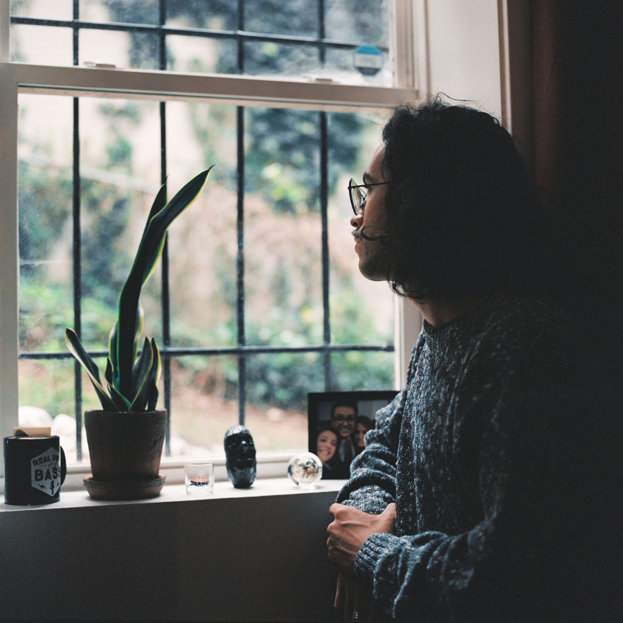 Jordi looks pensively outside a window.