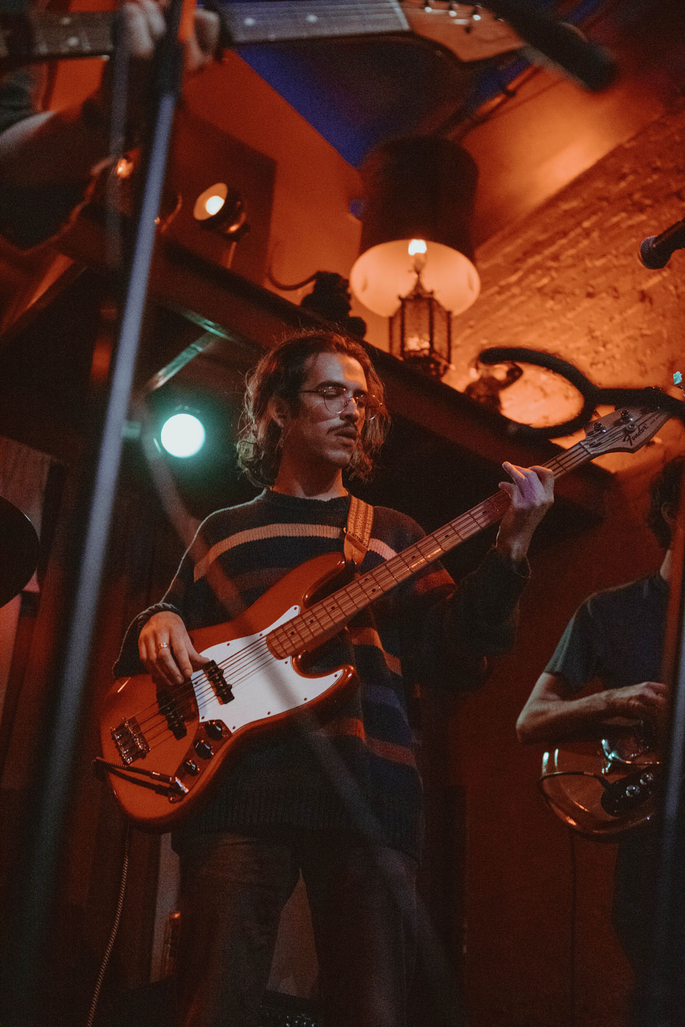 Jordi on stage strumming the bass guitar.