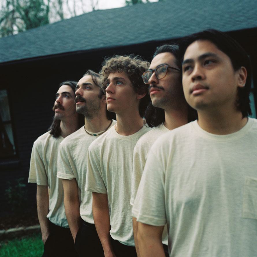 Canary Affair's five members dressed identically, stairing off into the distance.