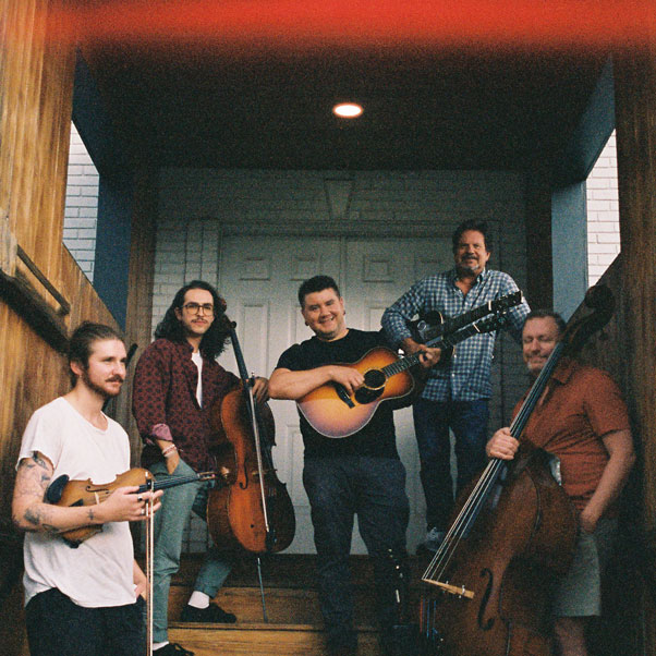 Standard Candle's five members pose with their respective instruments in a stairwell.