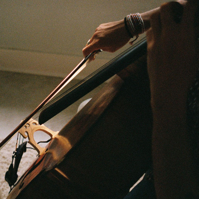 Top-down close-up of Jordi's hands playing the cello.