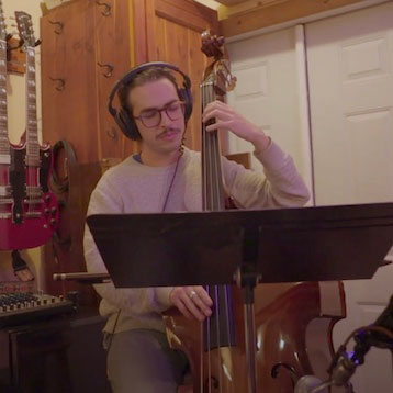 Jordi in the studio strumming the bass.